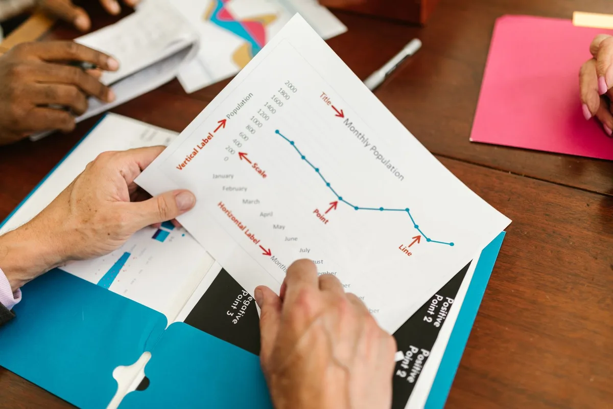 Team members examining a printed procedure document together during a meeting