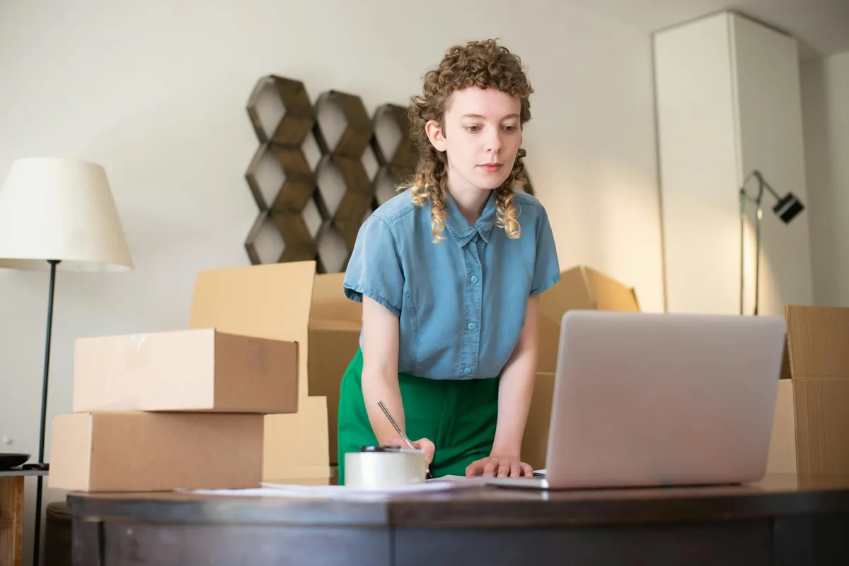 Businessman packing products and managing an online store from his desk with a laptop